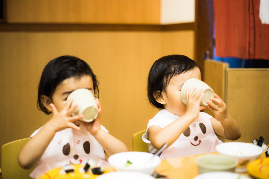 牛乳を飲む双子の乳幼児